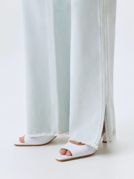 Светлые джинсы с разрезами 