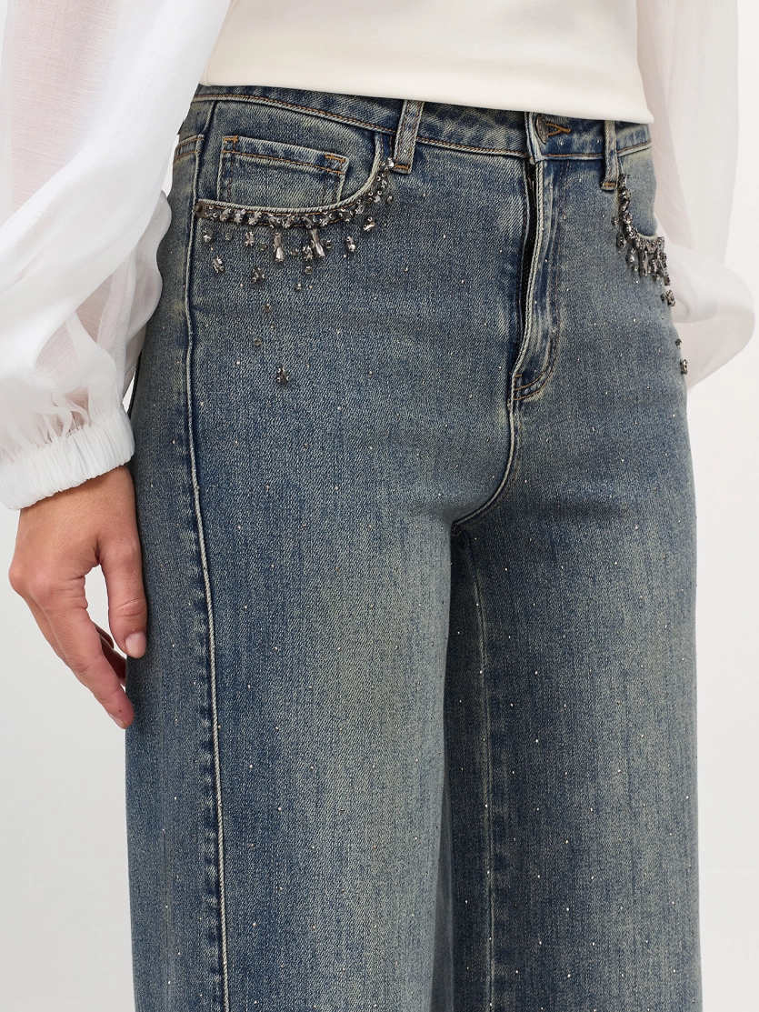 Джинсы с декором из мерцающих страз